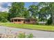 Attractive single-story brick house with a covered porch and a large, green front lawn and mature trees at 3888 Lindley Cir, Powder Springs, GA 30127