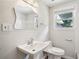 Bathroom features a pedestal sink and vintage mirror with a shower and a window at 6160 King Arthur Dr, Douglasville, GA 30135