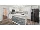 Bright kitchen with white cabinets, stainless steel appliances, tile backsplash, and a breakfast bar island at 6160 King Arthur Dr, Douglasville, GA 30135