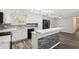 Modern kitchen featuring white cabinetry, stainless steel appliances, tile backsplash, and breakfast bar seating at 6160 King Arthur Dr, Douglasville, GA 30135