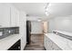 A modern kitchen featuring stainless steel appliances, white cabinets, gray backsplash, and marble countertops at 6160 King Arthur Dr, Douglasville, GA 30135