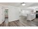 A cozy living area with wood floors, neutral paint, and an open layout to the kitchen area at 6160 King Arthur Dr, Douglasville, GA 30135