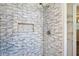 Updated tiled shower with unique white tiles, chrome shower head, and a built-in tiled niche at 6160 King Arthur Dr, Douglasville, GA 30135