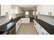 Modern kitchen with stainless appliances, dark countertops, white cabinets, and hardwood floors at 662 Gary Nw Rd, Atlanta, GA 30318