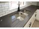 Close-up of a stainless steel kitchen sink with dark countertops and white cabinetry at 662 Gary Nw Rd, Atlanta, GA 30318