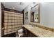 Charming bathroom featuring a granite countertop, decorative mirror, and tiled shower at 1080 Peachtree Ne St # 1208, Atlanta, GA 30309