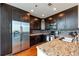 Modern kitchen featuring stainless steel appliances, dark cabinets, granite countertops, and hardwood floors at 1080 Peachtree Ne St # 1208, Atlanta, GA 30309