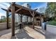 Outdoor cooking area under a wooden pergola, featuring an open bar, grill, and outdoor seating at 1080 Peachtree Ne St # 1208, Atlanta, GA 30309
