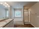 Bright bathroom featuring a double vanity with white cabinets, a tub and glass enclosed shower at 173 Parkview Place Dr, Mcdonough, GA 30253