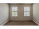 Carpeted bedroom featuring neutral paint, trim and baseboards, plus two bright windows at 173 Parkview Place Dr, Mcdonough, GA 30253