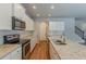 Well-lit kitchen featuring an island, granite countertops, stainless appliances, and wooden floors at 173 Parkview Place Dr, Mcdonough, GA 30253