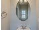 Half-bathroom with vanity, oval mirror, modern fixtures, and neutral wall paint at 173 Parkview Place Dr, Mcdonough, GA 30253