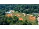 Aerial view of baseball fields and a community pool surrounded by trees, highlighting the recreation at 2343 Hunting Valley Dr, Decatur, GA 30033