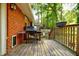 A wooden back deck features a grill, railing, and serene views of the surrounding trees at 2343 Hunting Valley Dr, Decatur, GA 30033