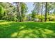 Spacious backyard with lush green grass and mature trees providing ample shade and privacy at 2343 Hunting Valley Dr, Decatur, GA 30033
