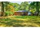This large, green backyard has a deck, trees, and a brick home at 2343 Hunting Valley Dr, Decatur, GA 30033