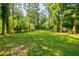 Large grassy backyard with mature trees and a fenced area, offering plenty of space at 2343 Hunting Valley Dr, Decatur, GA 30033