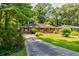 Charming brick home with well-manicured lawn, mature trees, and long driveway at 2343 Hunting Valley Dr, Decatur, GA 30033