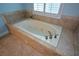 Close up of tiled bathtub with jacuzzi jets and chrome fixtures at 3423 Mulberry Lane Ct, Dacula, GA 30019