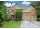 Beautiful brick home featuring a two-car garage, lush landscaping, and classic architectural details at 3423 Mulberry Lane Ct, Dacula, GA 30019