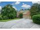 Traditional brick home with mature trees, a two-car garage and a long driveway at 3423 Mulberry Lane Ct, Dacula, GA 30019