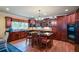 Gourmet kitchen features cherry cabinets, granite counters, island with cooktop and seating at 3423 Mulberry Lane Ct, Dacula, GA 30019