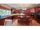 Gourmet kitchen features cherry cabinets, granite counters, island with cooktop and seating at 3423 Mulberry Lane Ct, Dacula, GA 30019