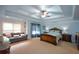 Spacious main bedroom featuring a tray ceiling, ceiling fan, and sitting area at 3423 Mulberry Lane Ct, Dacula, GA 30019