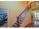 Elegant staircase with wood treads and iron railing leads to the upper level at 3423 Mulberry Lane Ct, Dacula, GA 30019