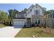 Charming two-story home with a stone facade, a well-manicured lawn, and an attached two-car garage at 4435 Beechnut Cir, Cumming, GA 30028