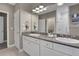 Bathroom featuring double sinks with granite countertops, a large mirror, and a glass-enclosed shower at 659 Holcomb Bridge Rd, Norcross, GA 30071