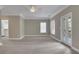 Large carpeted primary bedroom featuring neutral walls, crown molding, and private balcony access at 659 Holcomb Bridge Rd, Norcross, GA 30071
