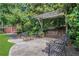Outdoor patio area featuring a pergola, swing, chairs and mature landscaping providing shade and privacy at 659 Holcomb Bridge Rd, Norcross, GA 30071