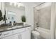 This well-lit bathroom has a shower-tub combo with gray tile and white cabinets at 115 Ivey Way, Woodstock, GA 30188