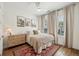 This charming bedroom has wood floors, a ceiling fan, neutral walls and a beautiful rug at 115 Ivey Way, Woodstock, GA 30188