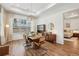 Open-concept dining room with hardwood floors, decorative lighting, and view into another room at 115 Ivey Way, Woodstock, GA 30188