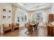 Bright dining room featuring a modern light fixture, wood floors, and large windows at 115 Ivey Way, Woodstock, GA 30188