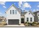 Charming two-story home featuring a black garage door, brick accents, and inviting front entrance at 115 Ivey Way, Woodstock, GA 30188