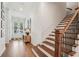 Bright foyer with hardwood floors, staircase, and stylish decor, creating an inviting entrance at 115 Ivey Way, Woodstock, GA 30188