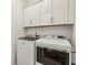 This laundry room features front loading washer and dryer and white cabinets for storage at 115 Ivey Way, Woodstock, GA 30188