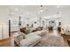 Open-concept living room featuring hardwood floors, modern lighting, and seamless flow to the kitchen at 115 Ivey Way, Woodstock, GA 30188