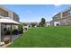 Spacious backyard with grassy lawn, patio, BBQ grill, and view of other townhomes at 299 Azalea Cir, Cumming, GA 30040