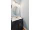 Powder bathroom with a black vanity, white countertops, round mirror, and modern vanity light at 299 Azalea Cir, Cumming, GA 30040