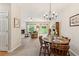 Cozy dining area with wood table, chandelier, and open access to living room with fireplace at 299 Azalea Cir, Cumming, GA 30040