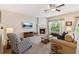 Cozy living room with a fireplace, ceiling fan, and large windows at 299 Azalea Cir, Cumming, GA 30040