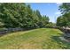 Large backyard features a grassy lawn, bench, and tall trees bordering the property at 299 Azalea Cir, Cumming, GA 30040