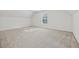 Spacious carpeted bonus room featuring a vaulted ceiling and a window, perfect for versatile use at 384 Daniel Mill Xing, Villa Rica, GA 30180