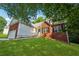 Exterior view of a brick home with a lush lawn, mature trees, and a welcoming entrance at 384 Daniel Mill Xing, Villa Rica, GA 30180