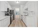 Modern kitchen with white cabinets, stainless steel appliances, and wood floors, offering a sleek look at 384 Daniel Mill Xing, Villa Rica, GA 30180