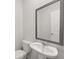 Modern powder room with a pedestal sink and decorative framed mirror at 4455 Manor Hill Dr, Union City, GA 30291